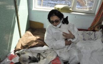 Felçli köpeğe anne şefkatiyle bakıyor