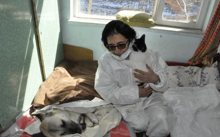 Felçli köpeğe anne şefkatiyle bakıyor