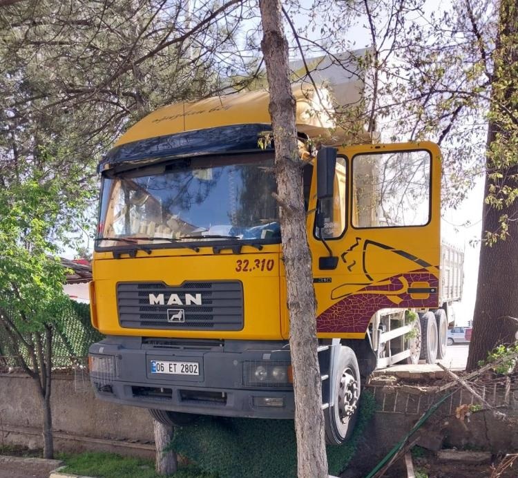 Yoldan çıkan kamyon duvarda asılı kaldı